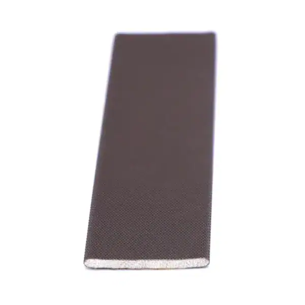 Close-up of a rectangular black object with textured surface, possibly a tech accessory or component, on a white background.